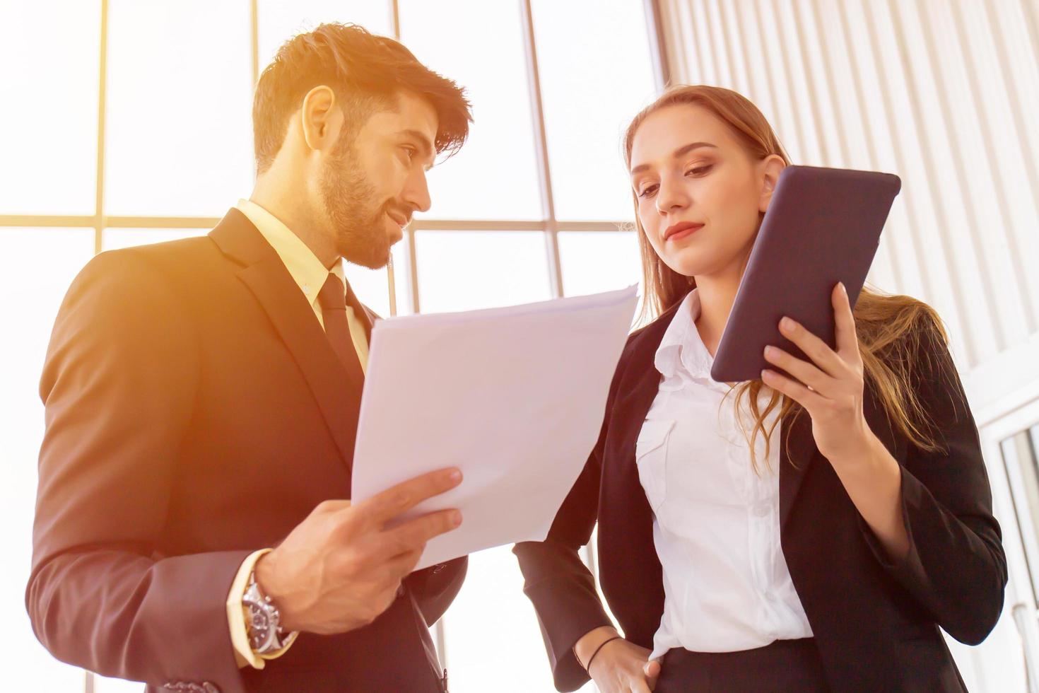 two-business-men-and-women-standing-meeting-in-the-office-free-photo